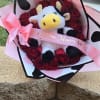 Bouquet of red roses with a plush cow and pink ribbon