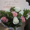 Bouquet of pink and white roses with a scalloped card