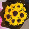 Bouquet of yellow sunflowers wrapped in black polka-dot paper