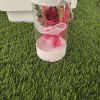 Single red rose in a clear gift box with pink ribbon