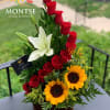 Tall arrangement of red roses, white lilies, and sunflowers in a basket