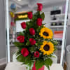 Red roses and sunflowers arranged in a pink box