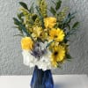 Bright yellow roses and gerbera daisies pop against billowy white hydrangeas and