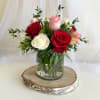 Bouquet of red, pink, and white roses in a glass vase