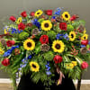 Large arrangement of red roses, sunflowers, and blue flowers