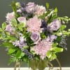 Lavender roses and pink chrysanthemums arranged in a glass vase