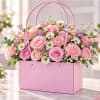 Pink flower arrangement in a pink handled gift box