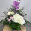 Tall floral arrangement with white and pink blooms in a dark vase
