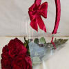 Bouquet of red roses wrapped in clear plastic with a red ribbon handle