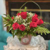 Pink rose arrangement in a small pot with baby's breath