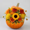 Orange pumpkin filled with yellow and orange flowers