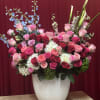 Large arrangement of pink and red roses in a white vase