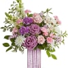 Pink and purple floral arrangement in a ribbed glass vase