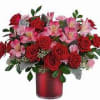 Red roses and pink alstroemeria in a red vase