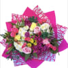 Bright mixed bouquet with pink, white, and yellow flowers wrapped in hot pink paper