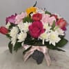 Mixed bouquet of roses, tulips, carnations, and white daisies in a vase