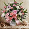 Pink and white mixed bouquet in a white vase with a satin ribbon