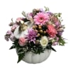 Pink and purple mixed bouquet arranged in a white pumpkin container