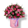 Pink roses arranged in a round box with a purple ribbon