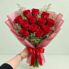 Bouquet of red roses wrapped in pink paper with a red ribbon