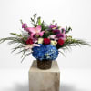 Mixed bouquet with pink lilies, roses, and blue hydrangea in a woven basket
