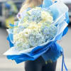 Bouquet of white roses and blue hydrangeas wrapped in blue paper