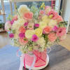 Pink and cream rose bouquet in a round pink box with ribbons