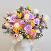 Mixed bouquet of roses, tulips, and orchids in a white hat box