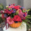Bright mixed bouquet arranged in a pumpkin container