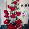 Tall arrangement of red roses with baby's breath in a white container