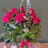 Pink roses in a glass vase with eucalyptus and fern accents