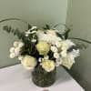 White roses and chrysanthemums in a glass vase with eucalyptus