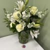White lilies and roses arranged in a glass vase