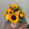 A bright and cheerful arrangement with warm yellow tones and lush greenery