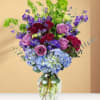 Bouquet of purple and blue flowers in a clear glass vase