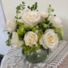White roses and green hydrangeas in a glass vase