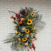 Tall floral standing spray with sunflowers, roses, and succulents