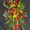 Tall standing floral spray with red, orange, and yellow flowers