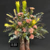 Tall floral arrangement in brown cowboy boots with pink and yellow blooms