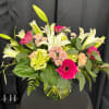 Mixed bouquet with white lilies, pink gerberas, and pale hydrangeas in a glass vase