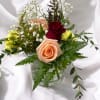 Mixed roses and filler flowers in a clear glass vase