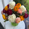 Mixed bouquet of roses and ranunculus in a green vase