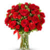 Red roses and carnations in a clear glass vase with a red ribbon
