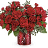 Red roses and red alstroemeria in a heart-patterned vase