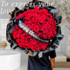 Large bouquet of red roses wrapped in black paper with a "Happy Anniversary" ribbon
