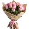 Bouquet of pink roses wrapped in brown paper with a pink ribbon