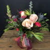 Bouquet of peach roses and pink flowers in a glass vase