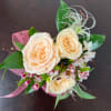 Peach roses with small pink-and-white flowers and ribbon wrap