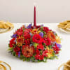 Low floral centerpiece with a red taper candle in the middle