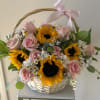 Basket arrangement of pink roses and sunflowers with a pink ribbon